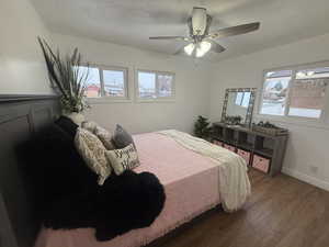 Bedroom featuring ceiling fan, dark hardwood / wood-style flooring, and a textured ceiling