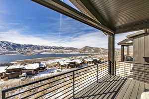 Snow covered back of property with a mountain view