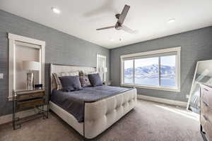 Carpeted bedroom with ceiling fan and a mountain view