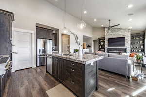 Kitchen featuring stainless steel appliances, a kitchen island with sink, dark wood-type flooring, sink, and high vaulted ceiling