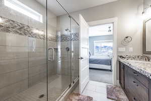 Bathroom featuring tile patterned floors, vanity, and a shower with door