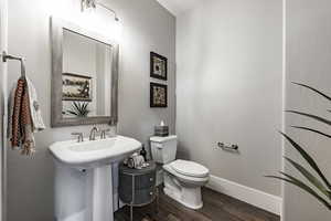 Bathroom featuring hardwood / wood-style flooring, toilet, and sink