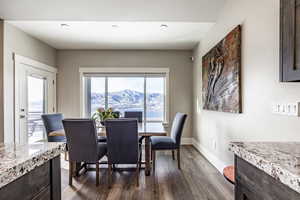 Dining area with a mountain view and dark wood-type flooring