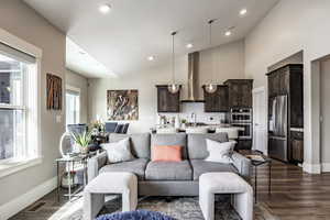 Living room with dark hardwood / wood-style floors, sink, and high vaulted ceiling