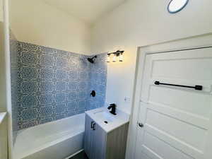 Bathroom with shower / tub combination, vanity, and a textured ceiling