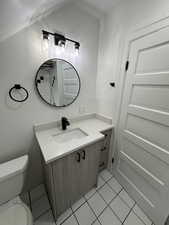 Bathroom with tile patterned flooring, vanity, and toilet