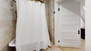 Bathroom with hardwood / wood-style floors and tile walls