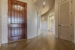 Entrance foyer with hardwood floors and an extra wide entry door.