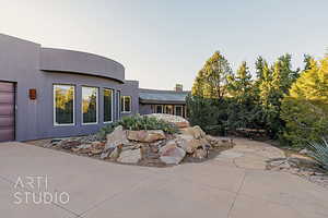 Patio terrace at dusk featuring a garage