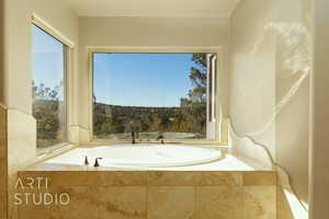 Bathroom featuring a relaxing tub and great views.