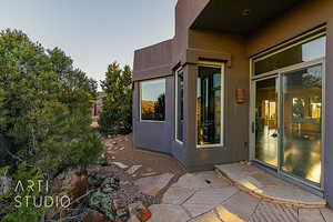 Exterior entry at dusk with a patio area