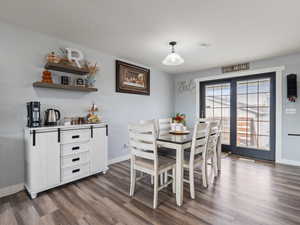 Dining area with dark hardwood / wood-style flooring