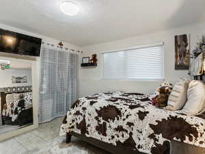 Tiled bedroom featuring a textured ceiling