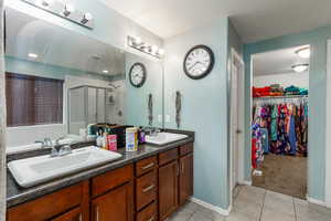 Bathroom with tile patterned flooring, vanity, and an enclosed shower