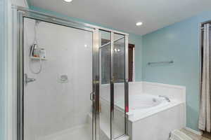 Bathroom with independent shower and bath and a textured ceiling