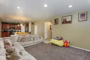 Living room with a notable chandelier and carpet floors