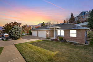 Ranch-style home with a yard and a garage