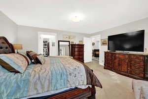 Carpeted bedroom with a walk in closet and a closet