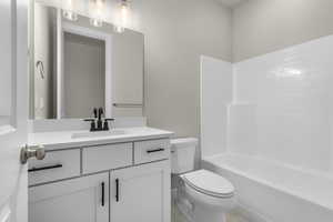 Full bathroom featuring vanity,  shower combination, and toilet