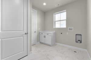 Washroom with cabinets, hookup for a washing machine, and electric dryer hookup