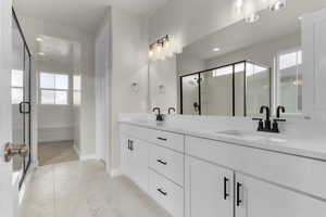 Bathroom with vanity, a shower with door, and a wealth of natural light
