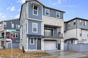 View of front facade featuring a garage and a balcony