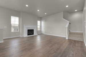 Unfurnished living room with hardwood / wood-style floors and a healthy amount of sunlight