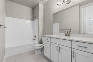 Full bathroom featuring tile patterned floors, vanity, toilet, and shower / bathing tub combination