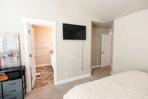 Carpeted bedroom featuring lofted ceiling