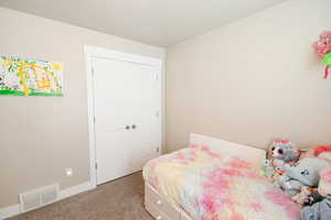 Carpeted bedroom with a closet