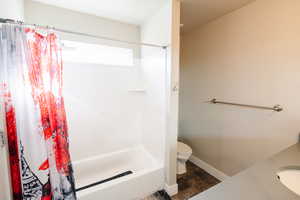 Full bathroom with wood-type flooring, sink, toilet, and shower / tub combo with curtain