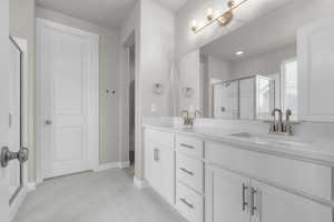 Bathroom with tile patterned flooring, vanity, and walk in shower