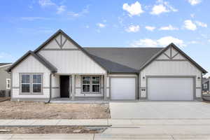 View of front of home featuring covered porch, a garage, and cooling unit