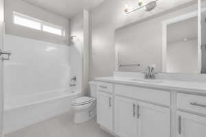 Full bathroom with tile patterned floors, vanity,  shower combination, and toilet