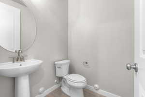 Bathroom with toilet, wood-type flooring, and sink