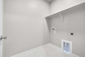 Laundry room with hookup for an electric dryer, light tile patterned flooring, and hookup for a washing machine