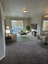 Unfurnished living room featuring carpet floors and a textured ceiling