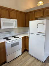 Kitchen featuring light wood-type flooring and white appliances