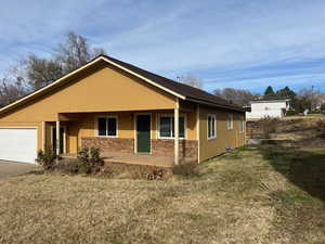 View of front of property with a garage and a front lawn