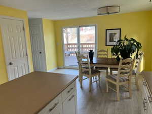 Dining room with a textured ceiling and light hardwood / wood-style flooring