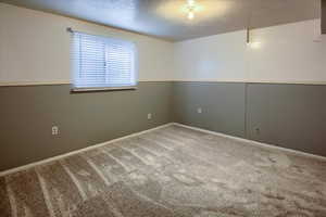 New Light gray carpet in bedroom featuring a textured ceiling