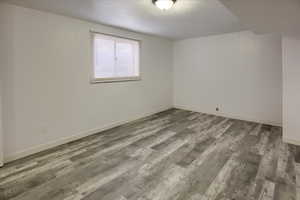 Unfurnished room with new hardwood / wood-style flooring