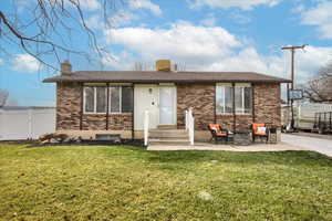 Front view of house with a yard and a patio