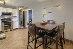 Tiled dining room featuring a textured ceiling