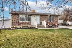 Front view of house with a lawn and a patio area. Vinyl railing