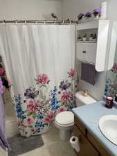 Full bathroom featuring tile patterned floors, vanity, shower / tub combo, and toilet