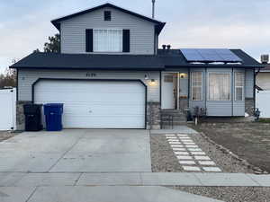 View of front of home featuring a garage and solar panels