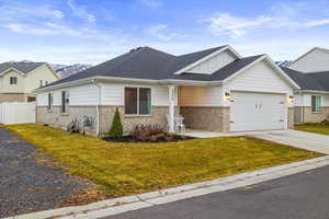 View of front of home featuring a mountain view, a front yard, and a garage