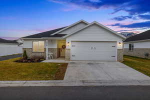 Craftsman-style home with a garage and a yard