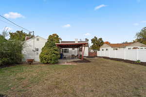 Back of house featuring a lawn and a patio area